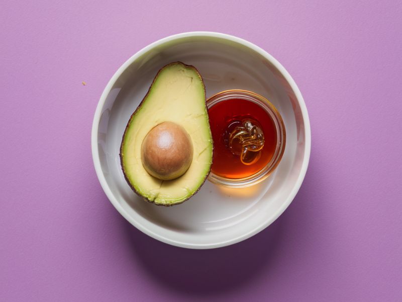 avocado and honey in plate mixed for face mask