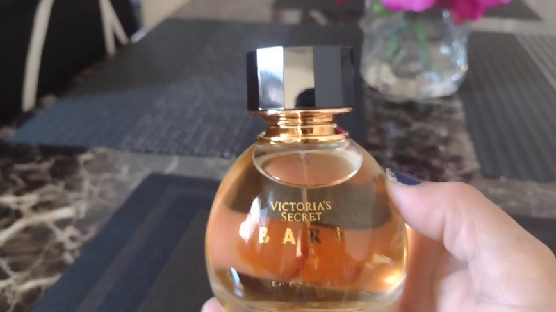 A hand holds a bottle of Victoria’s Secret Bare perfume