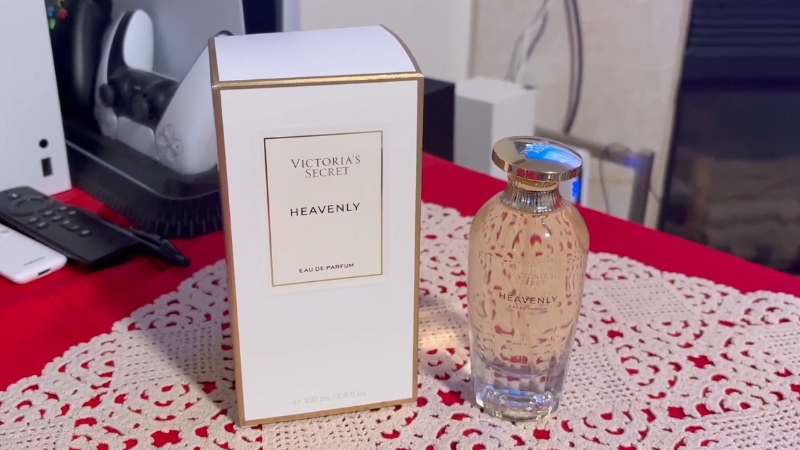 Victoria’s Secret Heavenly perfume bottle and box displayed on a lace-covered table with a soft indoor background