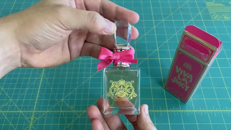 A person holds a clear bottle of Viva La Juicy by Juicy Couture perfume
