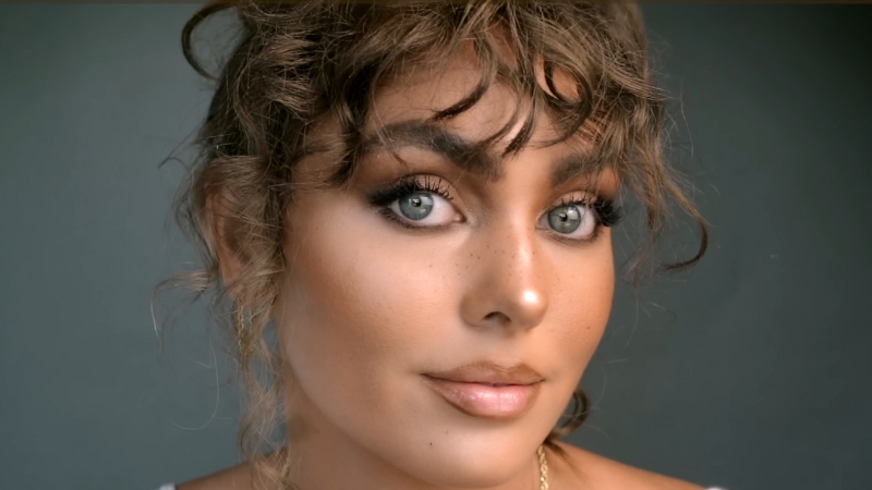 A woman with bronzed skin, soft contour, and warm brown tones showcasing the latte makeup look