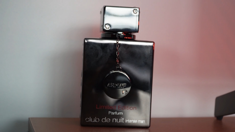 A close-up of the Armaf Club de Nuit Intense Man Limited Edition bottle with a metallic finish and chain detail