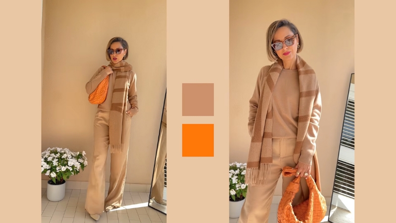 A woman wearing a beige monochromatic outfit with an orange bag, styled with sunglasses and a matching scarf