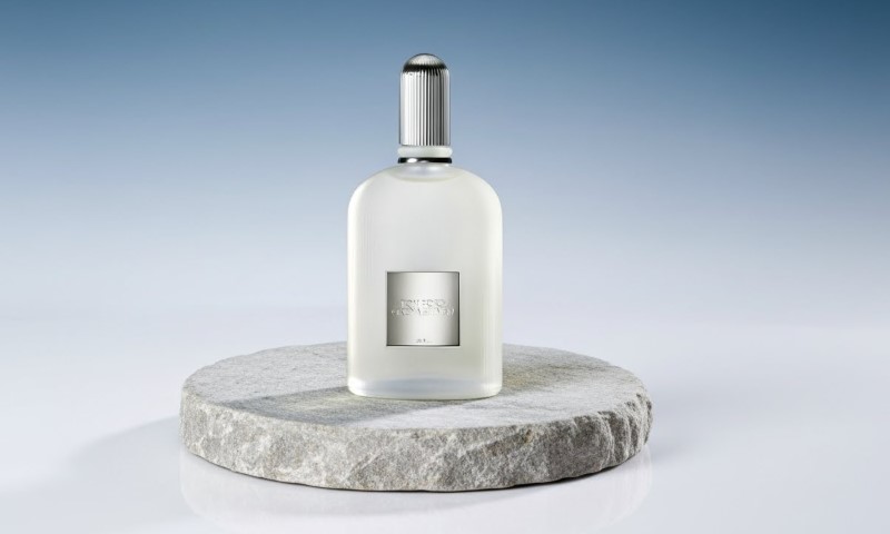 Grey Vetiver Eau de Parfum fragrance bottle on a white marble pedestal against a bright blue background