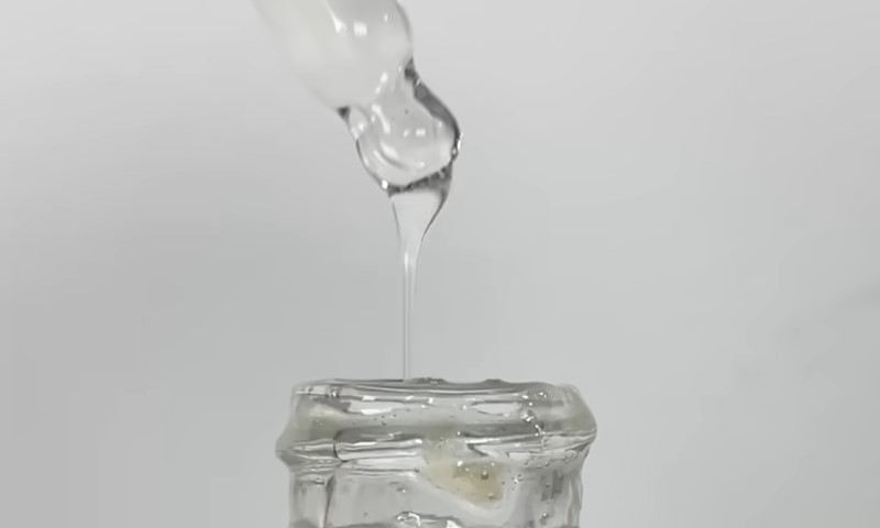 Clear, salicylic acid solution, dripping from a dropper into a glass container