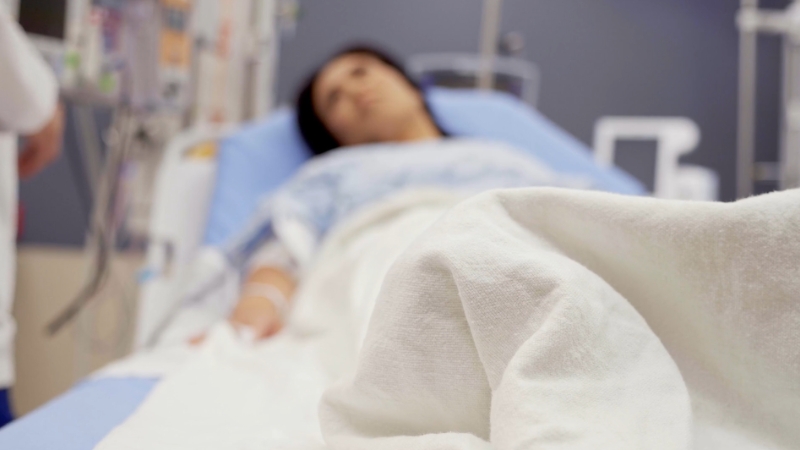 Patient resting in a hospital bed during immediate recovery after laparoscopic ovarian cyst surgery