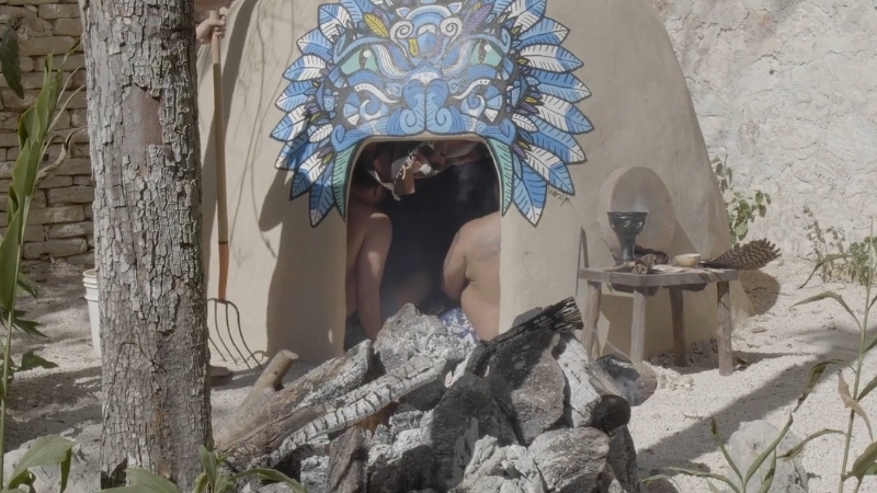 Participants enter a traditional temazcal sweat lodge during a Mesoamerican purification ritual