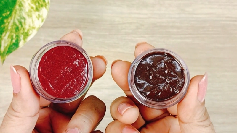 Hands holding small containers with beetroot paste used as a natural makeup tint for lips and cheeks