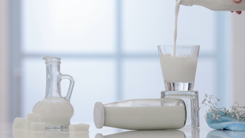 Milk poured into a glass and bottle for use in a natural skincare routine