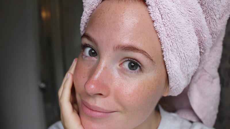 Person with a towel wrapped around their head showing clear, glowing skin