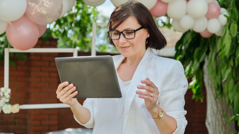 Wedding planner checks vendor details on a tablet before the celebration