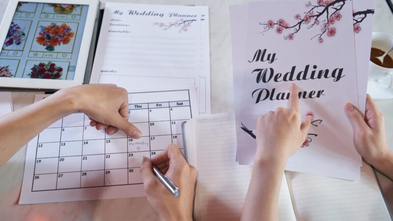 Couple marks a wedding date while organizing details in a planner