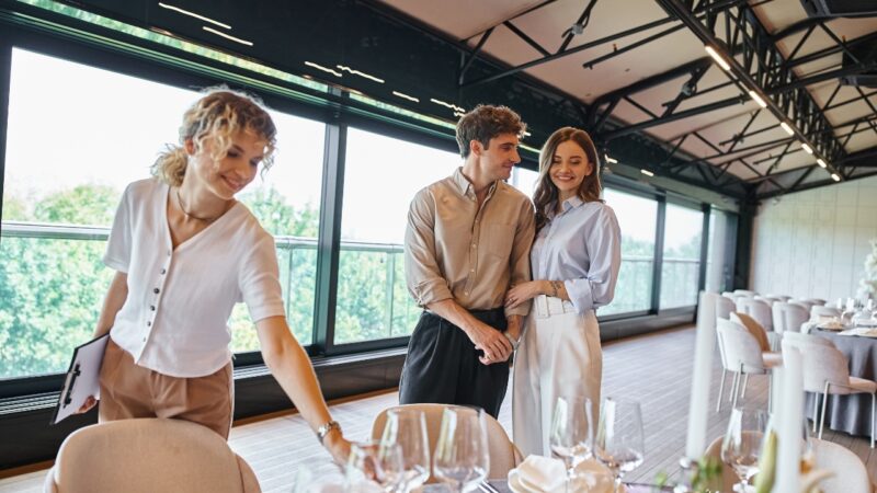 Couple reviews the wedding reception setup with a planner before the celebration